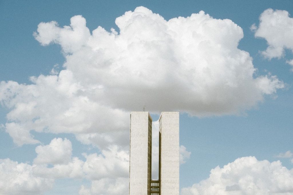 Vista do Congresso Nacional em Brasília sob um céu com nuvens